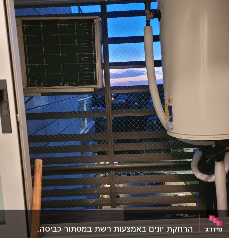 יחידת מזגן ורשת מתכת על חלון